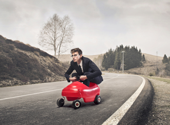 A man driving a toy car.