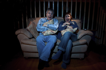 A picture of two people watching a scary movie.