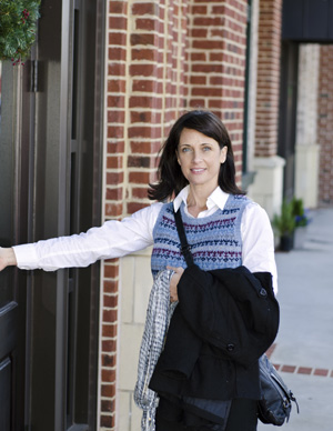A picture of a woman opening the door to a school.